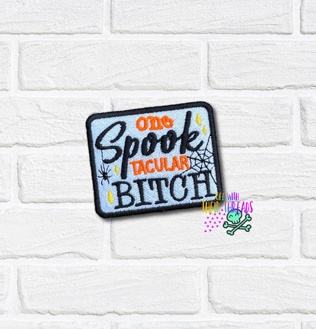 Embroidered patch with text 'One Spook-tacular Bitch' on a white brick background